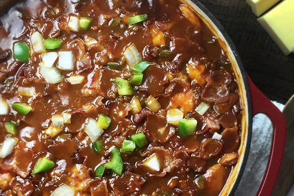 Easy oven baked beans with three types of beans, bacon, sausage, and cheddar cheese.